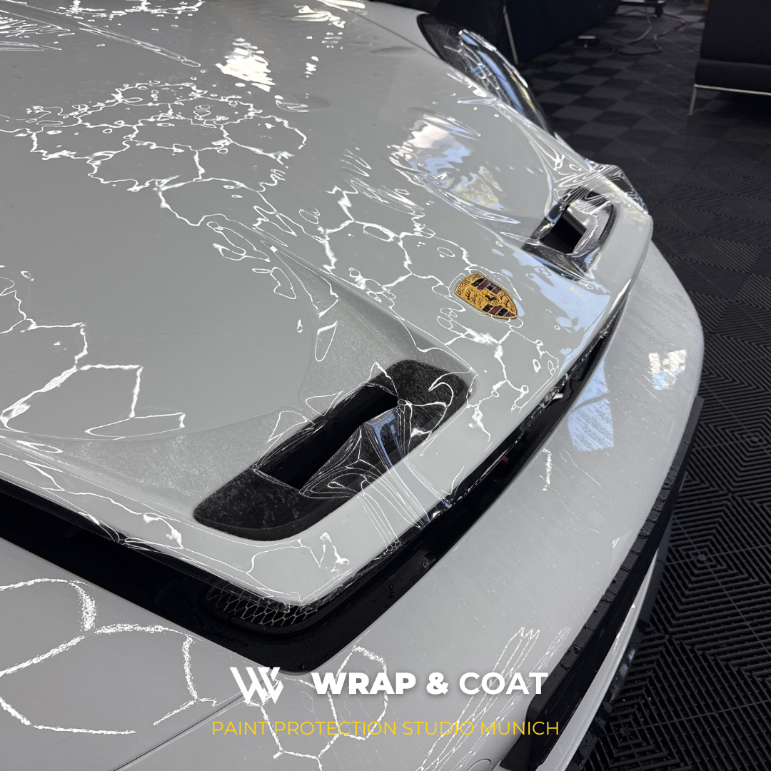 Transparente Lackschutzfolie auf der Motorhaube eines weißen Porsche